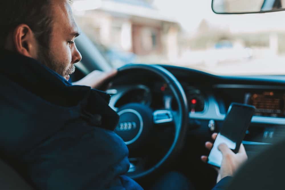 A man using a phone while in a car.