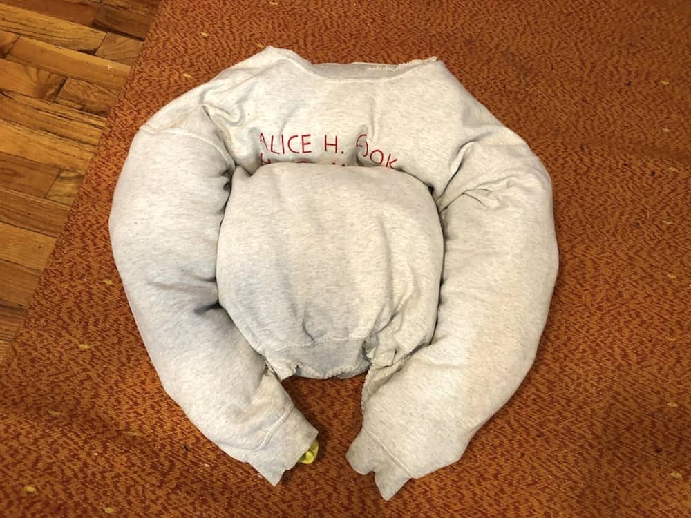 Making a DIY dog bed out of a sweatshirt.